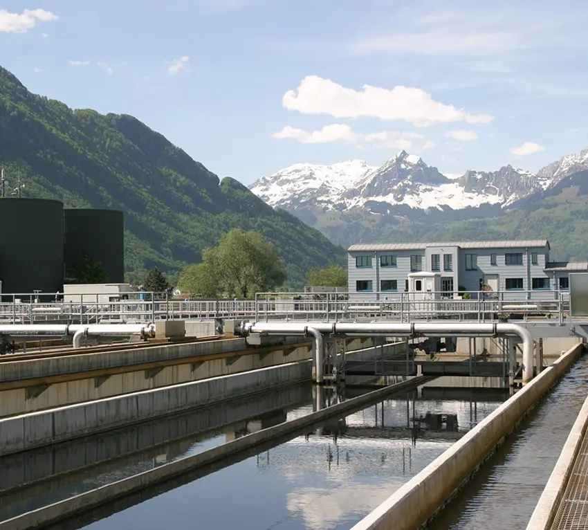 A wastewater treatment plant next to a mountain landscape