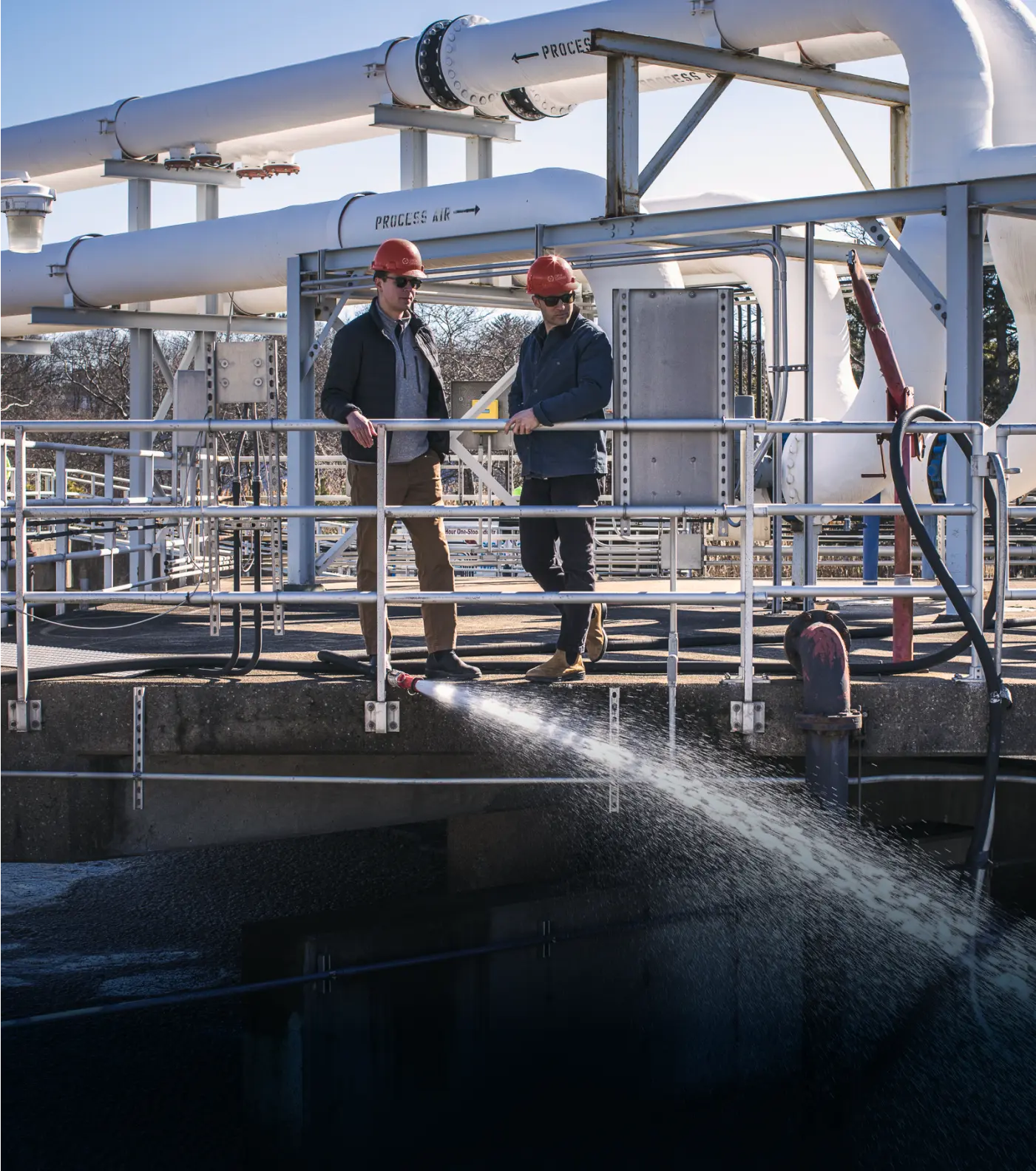 2 workers overlook a waste water treatment plant